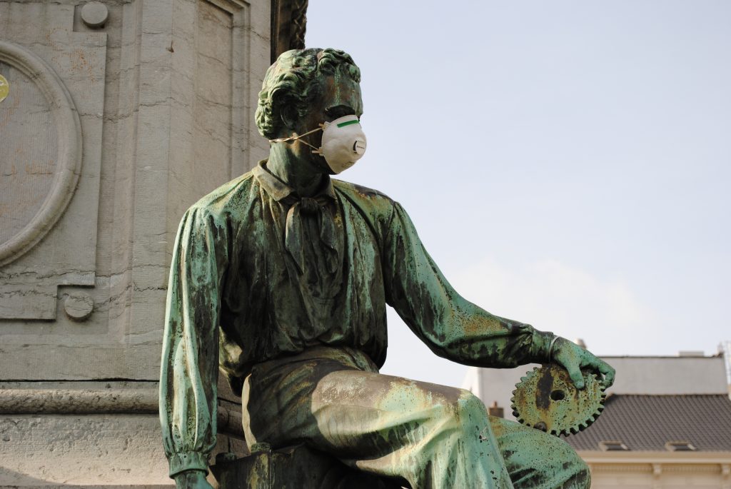 Das Foto zeigt eine Statue mit Atemschutzmaske auf dem Platz vor dem Europäischen Parlament.